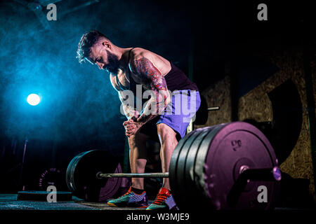 Muskulöse fitness Mann Vorbereitung einer Langhantel im modernen Fitnesscenter zu deadlift. Functional Training. Übung Snatch Stockfoto