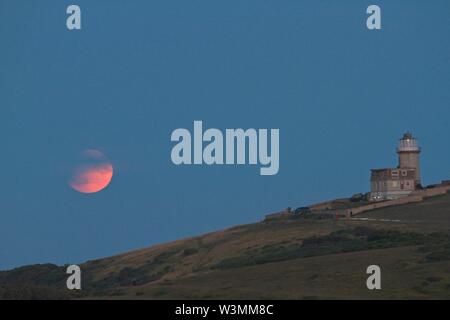 Beachy Head, UK. 16. Jul 2019. UK Wetter. Heute Abend voller Mond partielle Sonnenfinsternis steigt hinter Belle Tout Lighthouse in East Sussex, UK. Credit: Ed Brown/Alamy leben Nachrichten Stockfoto