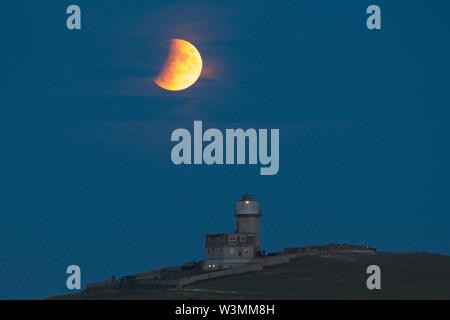 Beachy Head, UK. 16. Jul 2019. UK Wetter. Heute Abend voller Mond partielle Sonnenfinsternis steigt hinter Belle Tout Lighthouse in East Sussex, UK. Credit: Ed Brown/Alamy leben Nachrichten Stockfoto