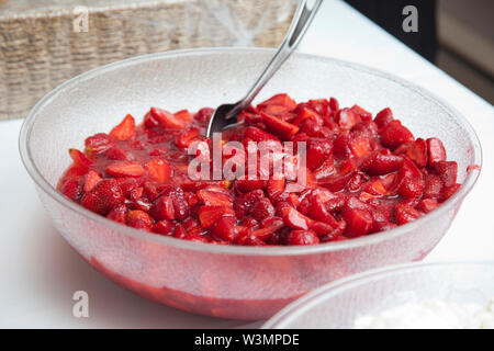 Eine große Plastik Schüssel, pürierte Erdbeeren mit einem Löffel bereit für Dessert Stockfoto