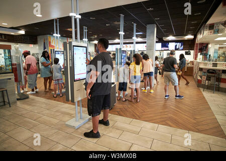 Kunden mit automatischem Bestellwesen in der Weltgrößten entertainment McDonalds Restaurant auf dem International Drive Orlando Florida USA Stockfoto