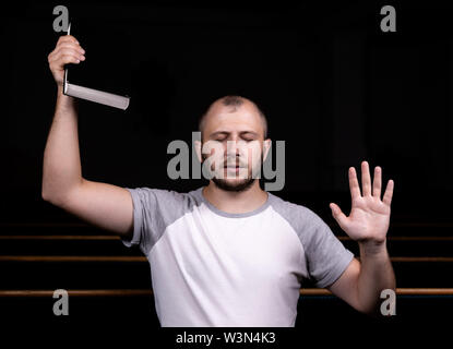 Ein junger Mann sitzt auf einer Kirche Sitzbank, liest in der Bibel und betet. Der Begriff der Religion, Gebet, Glauben Stockfoto