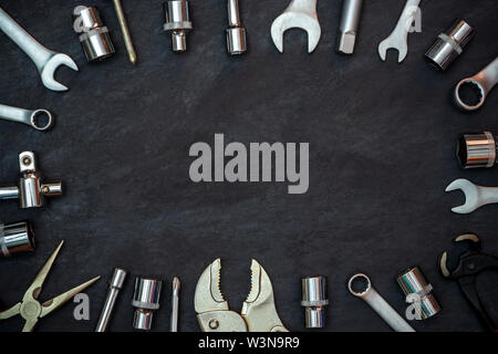 Handwerker Werkzeug auf schwarzem Zement Hintergrund. Kopieren Sie Platz für Ihren Text. Konzept der Wartung wie vor, die wiederverwendet werden können. Stockfoto