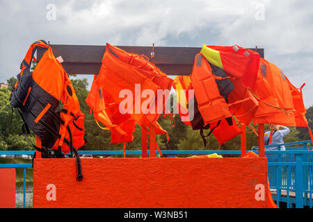 Rettungsweste für Schwimmen. Orange Schwimmweste. Orange Rettungsweste hängt am Haken. Stockfoto