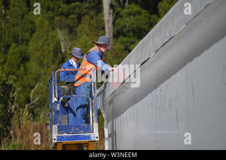 Greymouth, Neuseeland, 12. Dezember 2018: Handwerker sichern Sie den Kunststoff auf einen neuen Tunnel House. Stockfoto