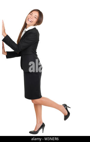 In voller Länge Portrait von glückliche junge Geschäftsfrau, stehen auf einem Bein mit den Händen auf Wand isoliert auf weißem Hintergrund Stockfoto