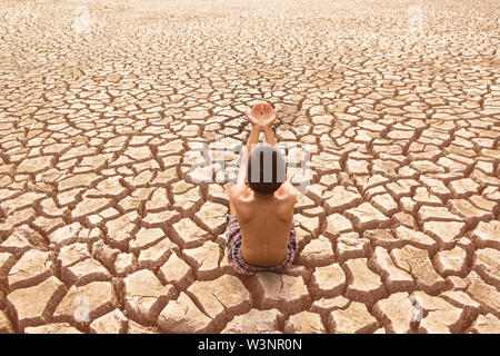 Kind sitzen auf Rissige Erde alte Mann sitzen auf Rissige Erde im trockenen Bereich Stockfoto