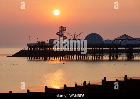 Herne Bay, Kent, Großbritannien. 17. Juli 2019: UK Wetter. Sonnenaufgang über Herne Bay Pier wie das herrliche Wetter fort. Mit der Sommerschulferien nähert sich die Leute in Scharen an die Küste und die Helter Skelter und Vergnügungen wird voll mit Touristen. Credit: Alan Payton/Alamy leben Nachrichten Stockfoto