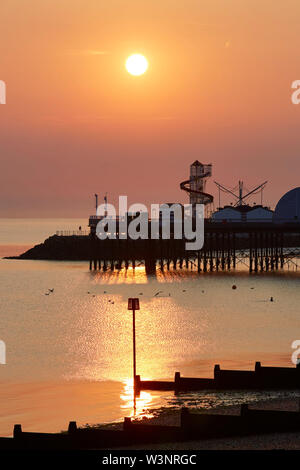 Herne Bay, Kent, Großbritannien. 17. Juli 2019: UK Wetter. Sonnenaufgang über Herne Bay Pier wie das herrliche Wetter fort. Mit der Sommerschulferien nähert sich die Leute in Scharen an die Küste und die Helter Skelter und Vergnügungen wird voll mit Touristen. Credit: Alan Payton/Alamy leben Nachrichten Stockfoto