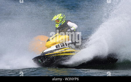 Jet Ski Konkurrent schneller Kurvenfahrt um gelbe Boje, wodurch an Menge Spray. Stockfoto