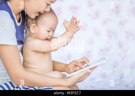 Asien Mutter Lesung Buch für Ihr Baby Stockfoto