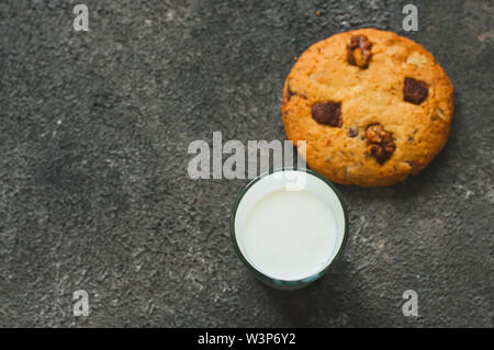 Cookes und Milch auf grauem Hintergrund. Ansicht von oben. Stockfoto