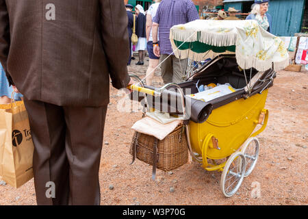 Mann mit einem altmodischen Kinderwagen mit einer Puppe, Großbritannien Stockfoto