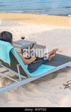 Ansicht der Rückseite des freiberuflichen Geschäftsfrau mit Laptop am Strand Stockfoto