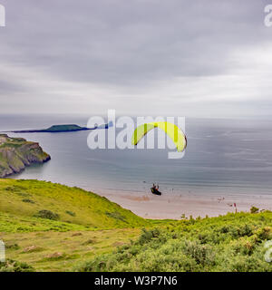 Gleitschirm in der Luft über Rhossili Bay nach weg von der Klippe des Gower Weg Stockfoto