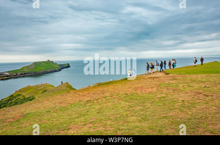 Eine Gruppe von Touristen auf den Klippen der walisischen Küste Weg mit Blick in Richtung der Wurm Kopf Stockfoto