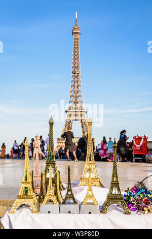 Der Eiffelturm in Paris, Frankreich, dargestellt mit Miniatur Eiffel Towers im Vordergrund, auf der Esplanade Trocadero von Straßenhändlern verkauft. Stockfoto