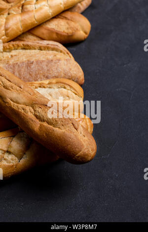 Auswahl an frischem Brot auf schwarzem Hintergrund. Ansicht von oben, flach, für Text. Konzept der hausgemachtes Brot Stockfoto