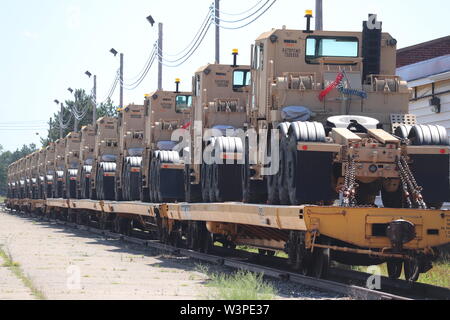 Militärische Fahrzeuge und Ausrüstungsgegenstände von der 1158th Transportation Company der Wisconsin National Guard sind auf triebwagen Juli 10, 2019, am Fort McCoy, Wis. Die Unternehmen, die Ausrüstung ist in Fort Hood, Texas, geladen, ein Teil einer großen Übung später im Jahr zu sein. Die Schiene wird geladen und die damit verbundenen Arbeiten wurde von der 1158th Soldaten und Mitarbeiter mit der Festung McCoy Logistics Readiness Center Transport Division abgeschlossen. (U.S. Armee Foto von Scott T. Sturkol, Public Affairs Office, Fort McCoy, Wis.) Stockfoto