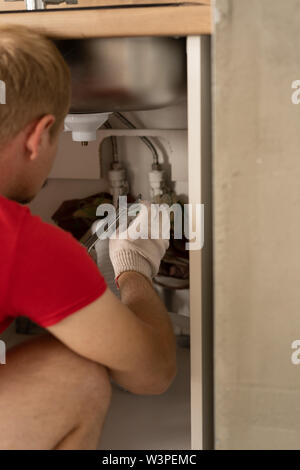 Reparatur und Dekoration. klempner Reparatur von Wasserleitungen in der Küche unter der Spüle Stockfoto
