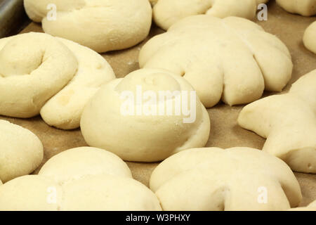 Raw Brötchen in verschiedenen Formen. Teig auf weissblech vor dem Backen Stockfoto