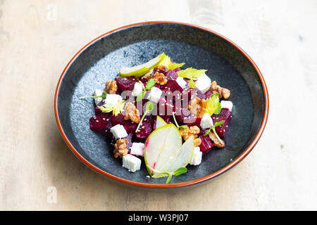 Nahaufnahme der frische, gesunde Rote-Bete-Salat mit Feta Käse, in Scheiben geschnittenen Äpfel, Walnüsse, sprießen garnieren Italienisch professioneller Koch Restaurant Speisen und Pla Stockfoto