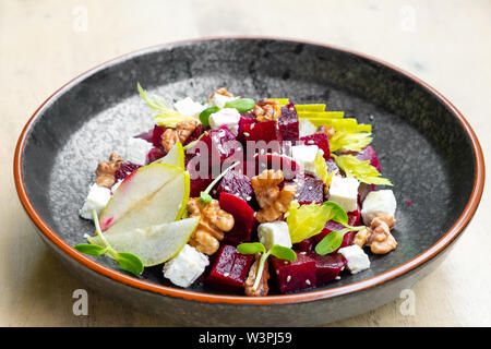 Nahaufnahme der frische, gesunde Rote-Bete-Salat mit Feta Käse, in Scheiben geschnittenen Äpfel, Walnüsse, sprießen garnieren Italienisch professioneller Koch Restaurant Speisen und Pla Stockfoto