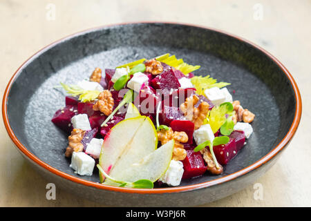 Nahaufnahme der frische, gesunde Rote-Bete-Salat mit Feta Käse, in Scheiben geschnittenen Äpfel, Walnüsse, sprießen garnieren Italienisch professioneller Koch Restaurant Speisen und Pla Stockfoto