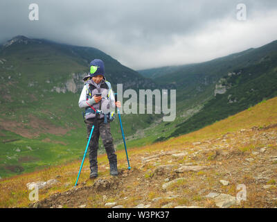 Kleine Junge mit Rucksack Wandern im Gebirge. Stockfoto