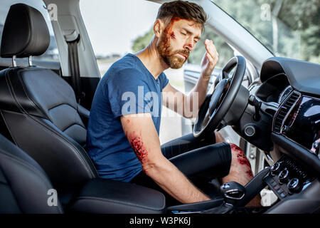 Befestigt mit Tiefe blutende Verletzungen Gefühl schockiert nach dem Verkehrsunfall im Auto Stockfoto