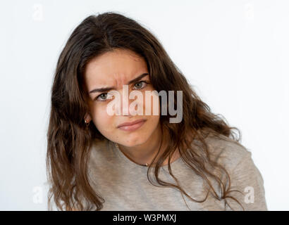 Nahaufnahme, Porträt einer hübschen jungen kaukasischen Mädchen mit einem wütenden Gesicht. Suchen empört und wütend in die Kamera schaut. Menschliche Mimik und em Stockfoto