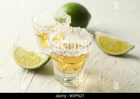 Tequila Schüsse mit Salz und Limette Schichten auf weißem Hintergrund Stockfoto
