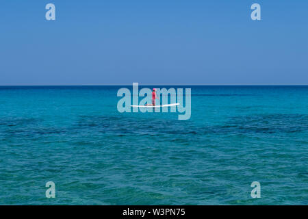 LEFKADA, Griechenland - 29. MAI 2018: Ältere weibliche Paddel Boarder im Meer weg von Agios Ioannis, Lefkada, Griechenland. Stockfoto