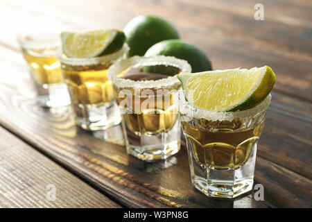 Tequila Schüsse mit Salz und Limette Schichten auf Holz, Tisch, Nahaufnahme Stockfoto