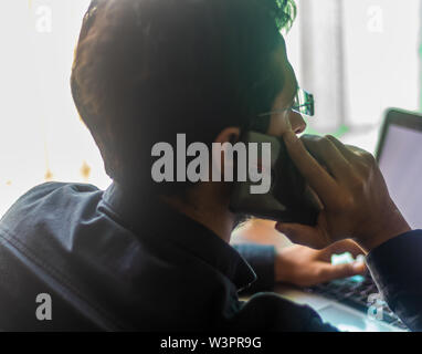 Indischer Geschäftsmann, der während der Arbeit telefoniert Stockfoto
