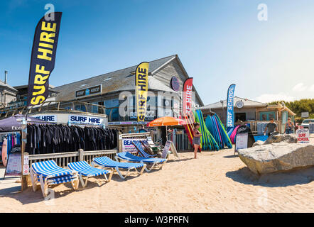 Surfbretter, Neoprenanzüge und Sonnenliegen zum Mieten aus den Fistral Surfen Mietwagen in Newquay in Cornwall zur Verfügung. Stockfoto