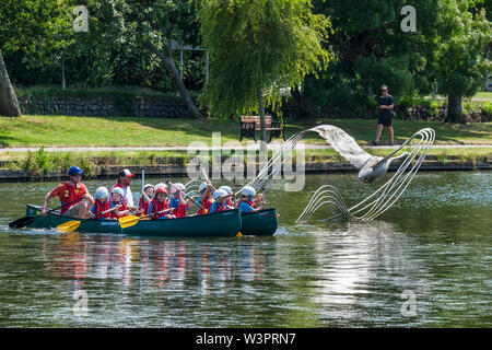 Grundschüler genießen einen freien Ausübung Aktivität Lektion, wie sie Spaß haben, Kanufahren auf trenance Garten See zum Bootfahren in Newquay in Cornwall. Stockfoto