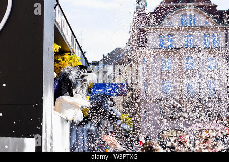 Marktplatz, Basel, Schweiz - März 13., 2019. Ein waggis wirft von seiner Karneval float Konfetti in die beobachtete Masse Stockfoto