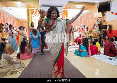 In einem traditionellen hinduistischen Hochzeit, ein Gast Tänze im Tempel, bevor die Braut und der Bräutigam ankommen. In Ozone Park, Queens, New York City. Stockfoto