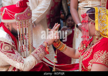 Eine Braut & Bräutigam berühren die Hände während eines traditionellen Shakti hinduistischen Hochzeitszeremonie in einem Tempel in Ozone Park, Queens, New York City Stockfoto
