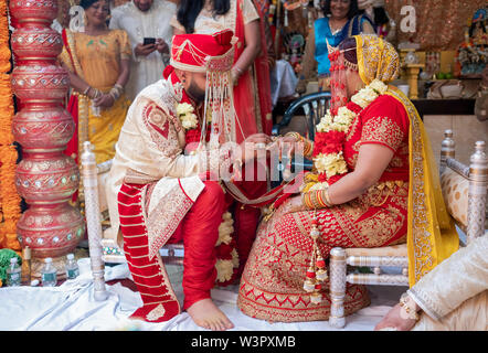 Eine Braut und Bräutigam exchange Ringe während des traditionellen hinduistischen Hochzeitszeremonie in einem Tempel in Ozone Park, Queens, New York City. Stockfoto