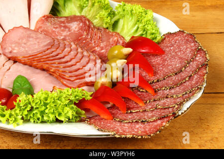 Scheiben geräucherter Wurst, Salami und Schinken auf Bankett Platte mit bunten Garnieren Stockfoto