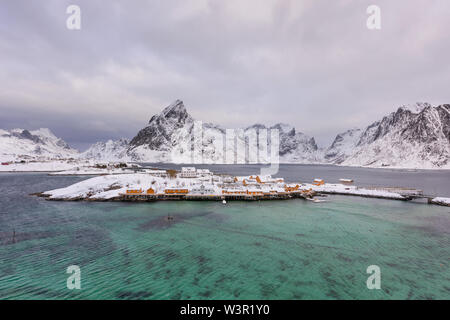 Typisch norwegische Landschaft. Wunderschöne Aussicht auf malerische Lofoten Winter Landschaft mit traditionellen gelben fisherman Rorbuer Kabinen in der historischen Stockfoto