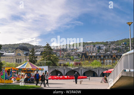 Schweizer Böschung. Wandern Menschen und Straßencafés. Berge und Häuser hinter Stockfoto