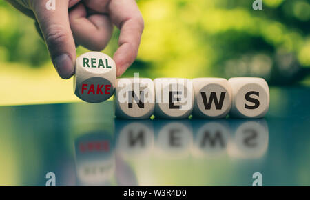 Hand einen Würfel und Änderungen der Ausdruck 'Fake news' auf 'real Nachrichten'. Stockfoto