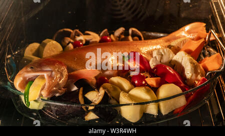 Kochen Fisch mit Gemüse im Backofen, zu Hause Stockfoto