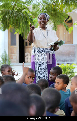 Katechist unterrichtet katholische Religion Klassen mit Studenten aus Epiphanie Vor- und Grundschule in Bagamoyo, Tansania Stockfoto