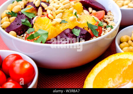 Vegetarisch Bulgur weizen und Quinoa Mittagessen Schüssel mit Orange Segmente, Kichererbsen, rote Beete und Tomaten Stockfoto
