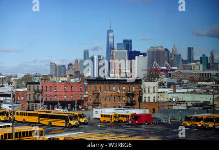 Schulbusse in Red Hook in Brooklyn geparkt mit Downtown Manhattan im Hintergrund Stockfoto