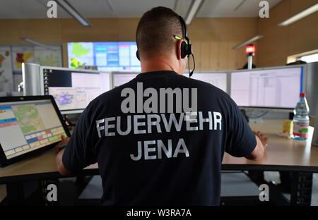 Jena, Deutschland. 17. Juli, 2019. Ein Mitarbeiter sitzt in der zentralen Leitstelle in der gefahrenprävention Zentrum Jena. Es ist verantwortlich für die mehr als 200.000 Einwohner und erstreckt sich auf die Bereiche von Jena, Saale-Holzland-Kreis, Weimar und Teilen des nördlichen Weimarer Region. Die zentrale Leitstelle ist eine der Stationen auf der Thüringer Ministerpräsident die multi-Tag Sommer Tour unter dem Motto '#FutureThuringia - Kluge Köpfe, innovative Prozesse". Foto: Martin Schutt/dpa-Zentralbild/dpa/Alamy leben Nachrichten Stockfoto